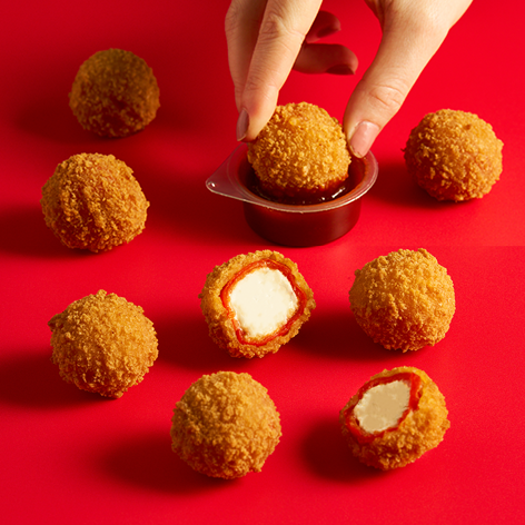 Peppadew bites being dipped in sauce